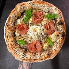 Pizza margherita Contemporanea élégante avec cornicione gonflé sur assiette noire